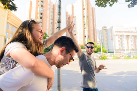 Happy group of young people walking together on sunny dayの写真素材