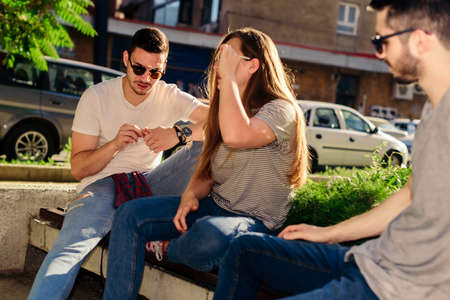 Group of friends enjoying in summer time while sitting on bench