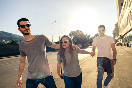 Group of friends having fun outdoors on summer time in downtown