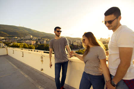 Three friends enjoying in the view on the city from rooftop