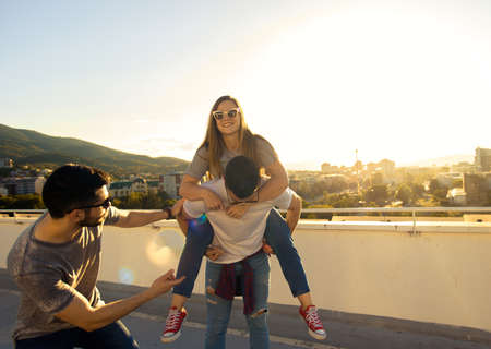 Portrait of young best friends relaxing on rooftop of the building in summer timeの写真素材