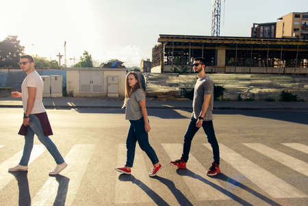 Portrait of young best friends walking on zebra crossing