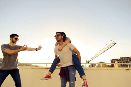 Portrait of young best friends relaxing on rooftop of the building in summer timeの写真素材
