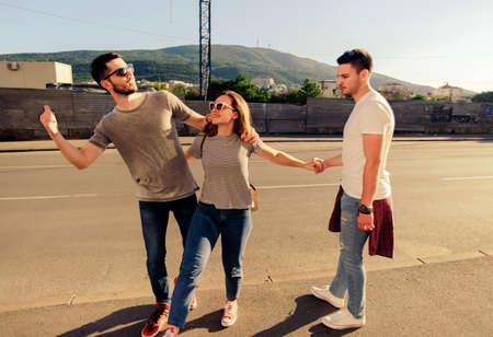 A group of friends walking on the sidewalk in an urban placeの写真素材