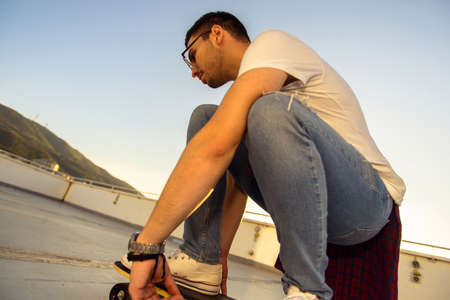 Portrait of urban boy having fun and driving skateboard on the balcony