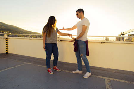 Photo of two young caucasian person while standing of the top on the buildingの写真素材