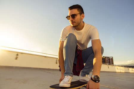 Handsome teenager cool acive boy riding skateboard on terraceの写真素材