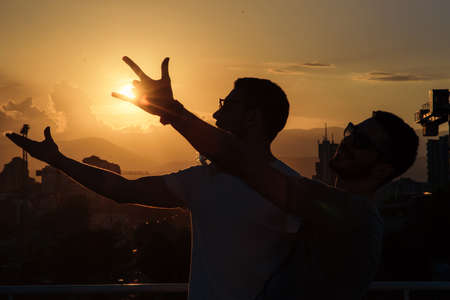 Young carefree friends having fun on the rooftop od the building on sunny dayの写真素材