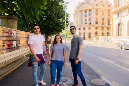 A group of friends walking on the sidewalk in an urban place
