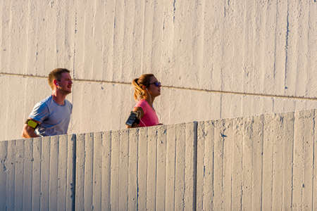Sweet couple is listening music while running through the cityの写真素材