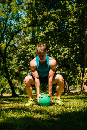 Sporty guy exercising outdoor with the medecine ballの写真素材