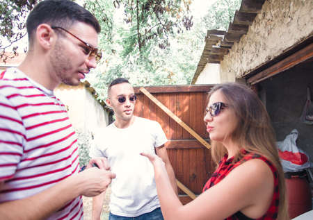 A group of friends talking in front of a parked car in the garage