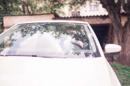 Handsome young Man parking the car in the garage on a sunny day