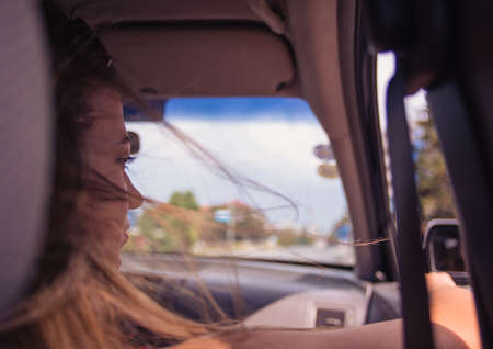 Happy Young Couple Driving in a Car in the city on a sunny day