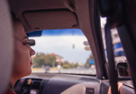 Happy Young Couple Driving in a Car in the city on a sunny day