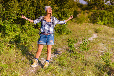 Breathing the fresh mountain air. Young woman hiking in the forest in the summer. Hiking concept in the mountain in summerの写真素材