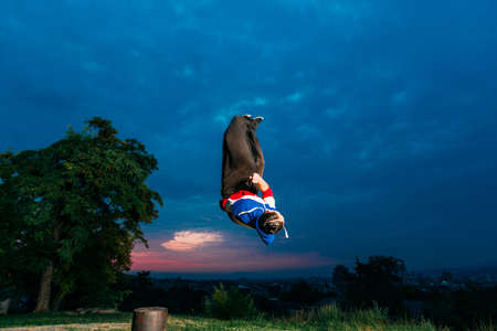 Sportive man doing acrobatic exercise while jumping