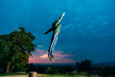 Full body portrait of parkour man jumping high in the park