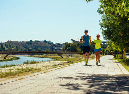 Beautiful couple jogging in nature living healthyの写真素材