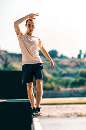 Parkour man walking and balancing on the edge of the wallの写真素材