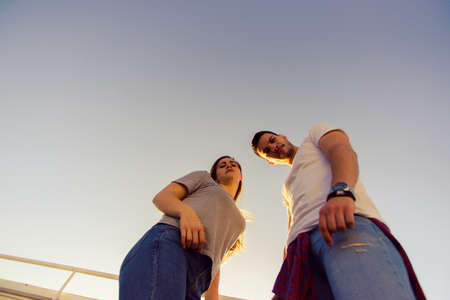 Two friends standing on the balcony at sunsetの写真素材