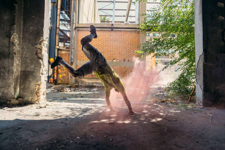 Man around colored bombs doing handstand outdoorsの写真素材