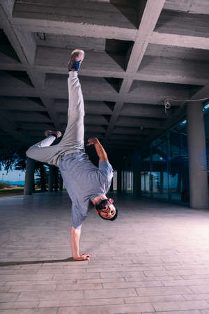 Sportive man training parkour handstand outdoor