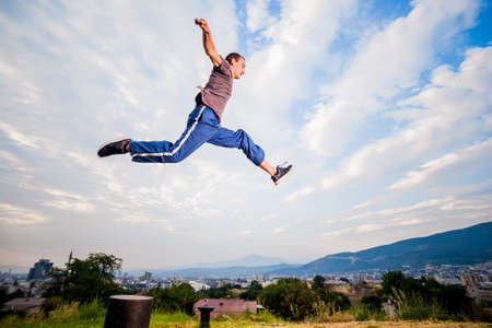 Full body portrait of parkour man jumping high in the parkの写真素材