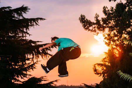 Free runner doing parkour exercise outdoor on sunsetの写真素材
