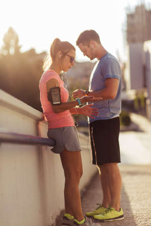 Young couple jogging for fitness in urban environment on a beautiful summer dayの写真素材