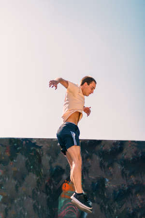 Young man doing parkour jumping at skatepark