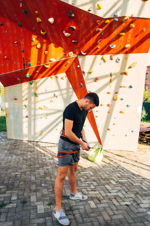Free climber putting his safety harness belt for climbingの写真素材