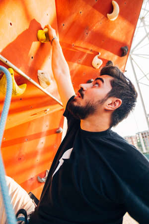 Handsome young man bouldering or rock climbing outdoorsの写真素材
