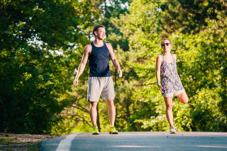 Young fit couple on the middle of the road doing exerciseの写真素材