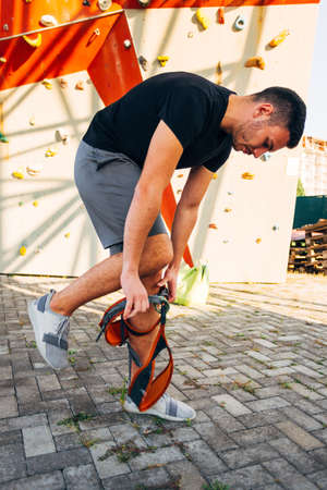 Free climber putting his safety harness belt for climbingの写真素材