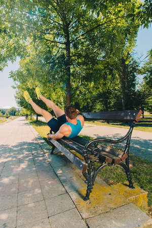 Attractive man doing stretch on the bench before runningの写真素材