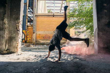 Man around colored bombs doing handstand outdoorsの写真素材