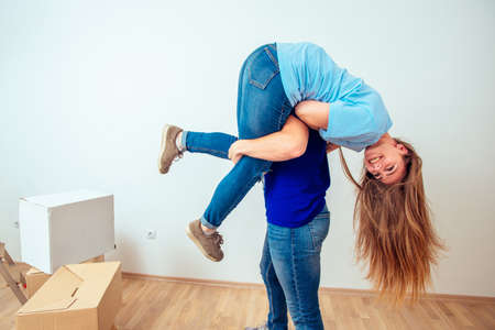 Young positive couple having fun in their new apartmentの写真素材