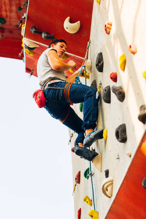 Young sporty man is bouldering in a climbing hallの写真素材
