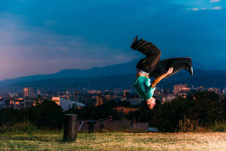 Sportive man doing acrobatic exercise while jumpingの写真素材