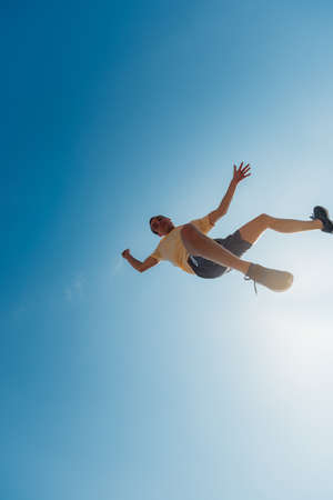 Parkour guy doing tricks in the air below the skyの写真素材