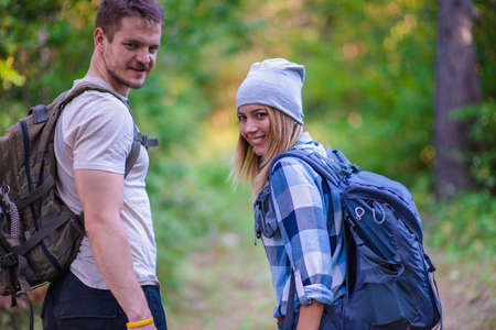 Young couple walking in the forest. Hiking concept in the mountain in summerの写真素材