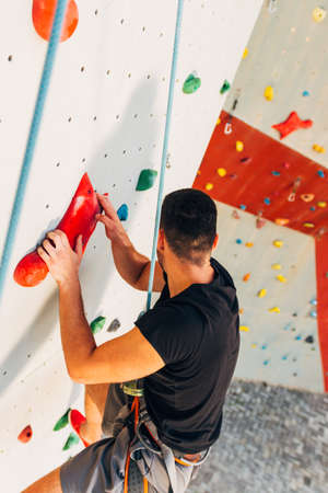 Free climber man climbing up on bouldering