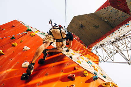 Young sporty man is bouldering in a climbing hallの写真素材