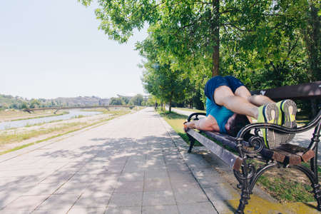 Attractive man doing stretch on the bench before runningの写真素材