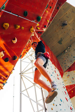 Man climber on artificial climbing wall in bouldering gymの写真素材