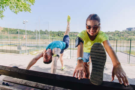 Runner athlete stretching legs outdoors in a park on benchの写真素材