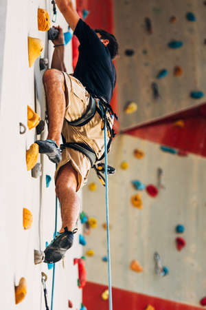Handsome young man bouldering or rock climbing outdoorsの写真素材