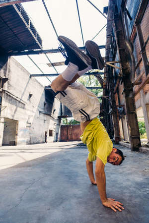 Parkour man in action while training handstand in abandoned factoryの写真素材