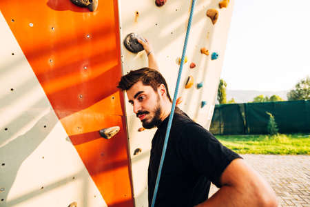 Man climber on artificial climbing wall in bouldering gymの写真素材